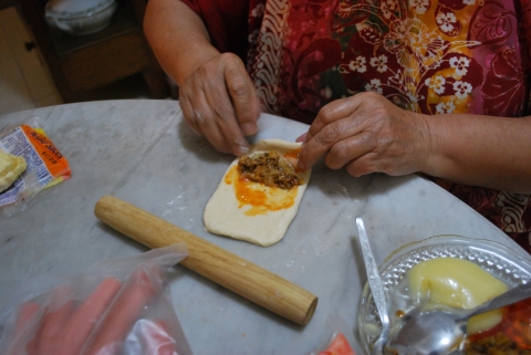 rolling the dough with sardine filling